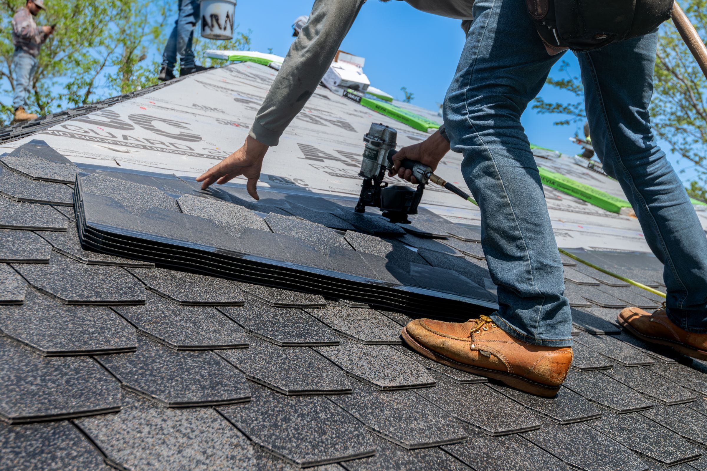 Close-up of a nail gun fastening architectural shingles