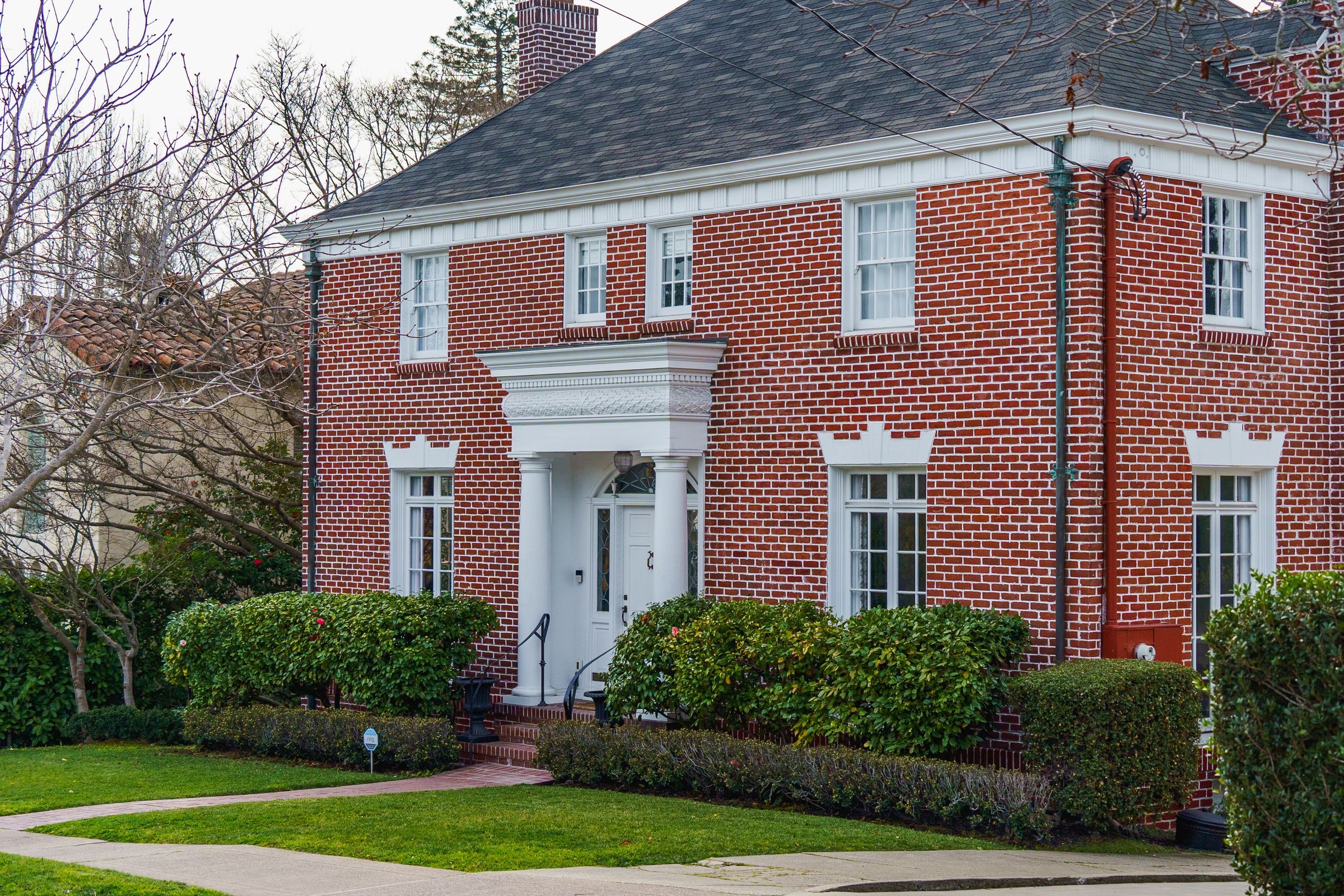 Brick colonial house with a steep hip roof